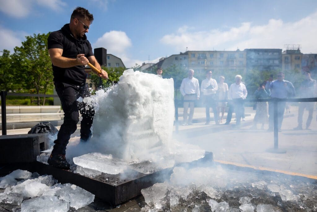 Gáborecz István szobrász kifaragja a palackot a hata lmas jegkockabol